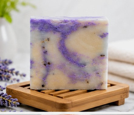 Lavender soap bar on wooden dish with lavender sprigs