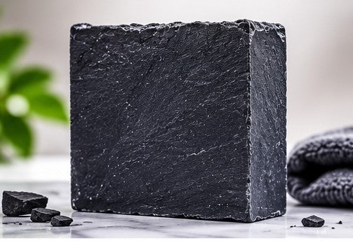 Peppermint tea tree charcoal soap bar on marble surface