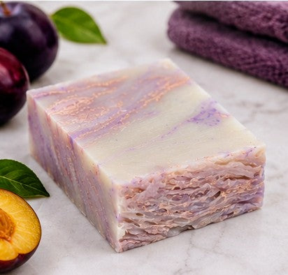 Plum sugar soap bar on marble with fresh plums